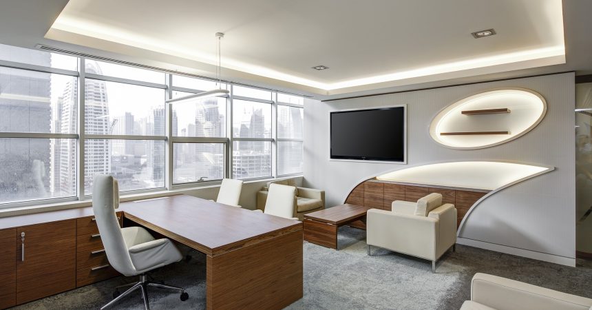 Escritório moderno com vista da cidade, móveis elegantes e área de reuniões informais.